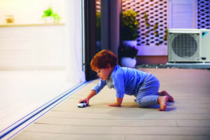 Daikin Fit unit in background, child playing with toy car on deck