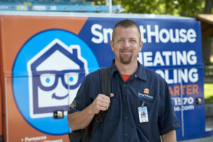 smarthouse technician smiling with workbag in front of company truck